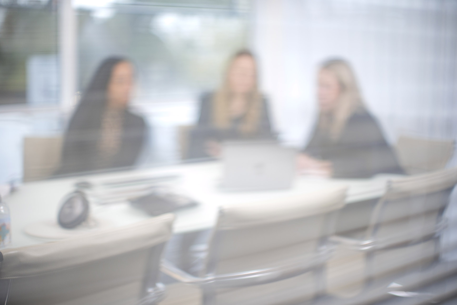 Three Headley Media colleagues in a meeting with a blurred overlay effect